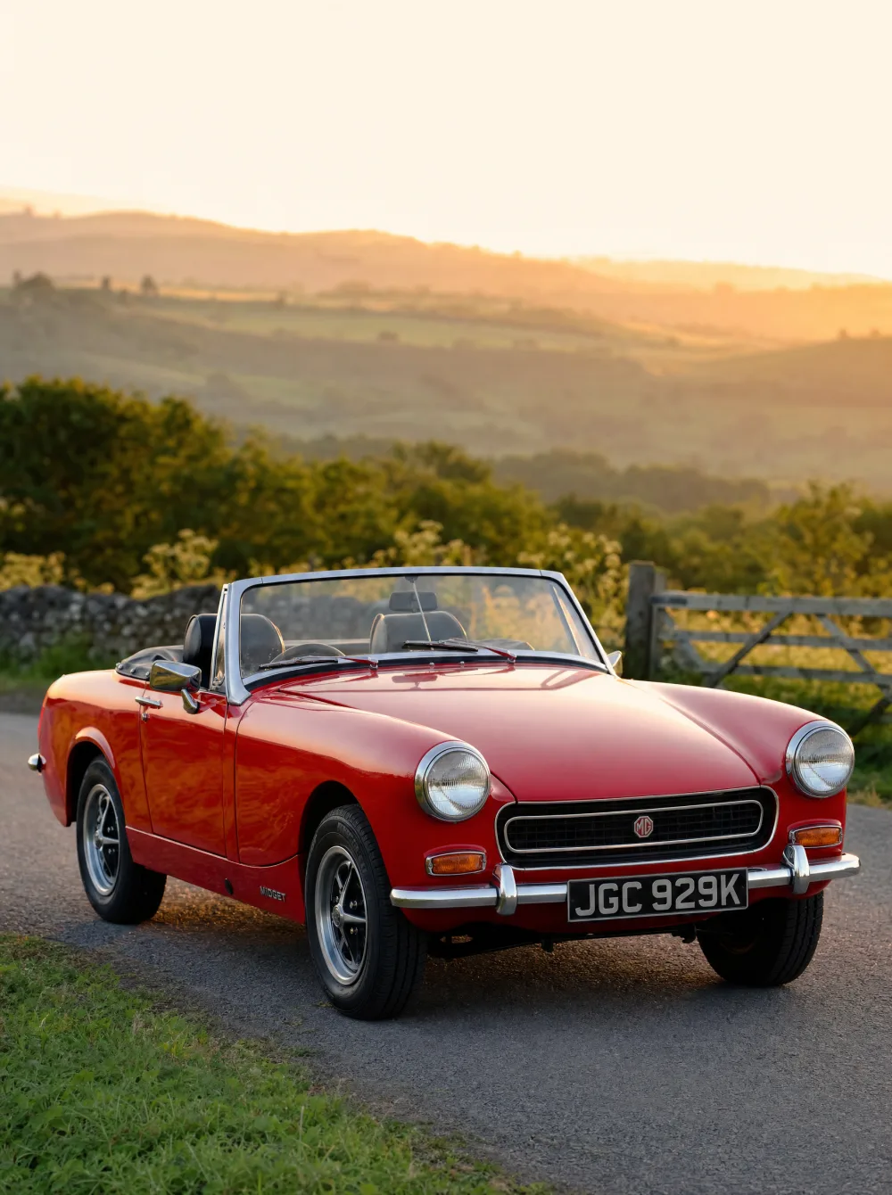 Klassieke MG Midget Mk3 roadster uit 1972 in Tartan Red, driekwart vooraanzicht in gouden ochtendlicht.